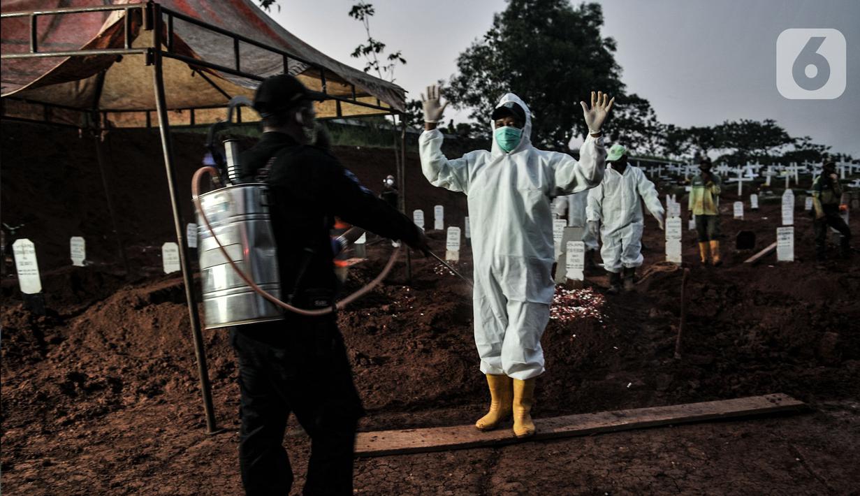 Petugas mengenakan alat pelindung diri (APD) dan baju hazmat saat proses pemakaman pasien Covid-19 di TPU Pondok Ranggon, Jakarta, Kamis (24/9/2020). Jumlah kumulatif kasus Covid-19 di Indonesia mencapai 262.022 orang per Kamis (24/9) dengan 10.105 jiwa meninggal dunia. (merdeka.com/Iqbal Nugroho)