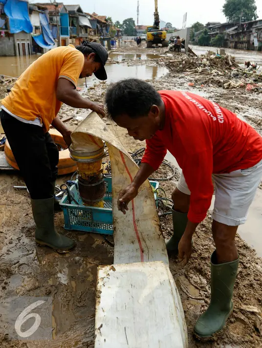 Petugas normalisasi Ciliwung menyiapkan pompa penguras air, Kampung Pulo, Jakarta, Rabu (25/11/2015). Pompa tersebut untuk mempercepat penyurutan banjir di pemukiman Kampung Pulo. (Liputan6.com/Yoppy Renato)