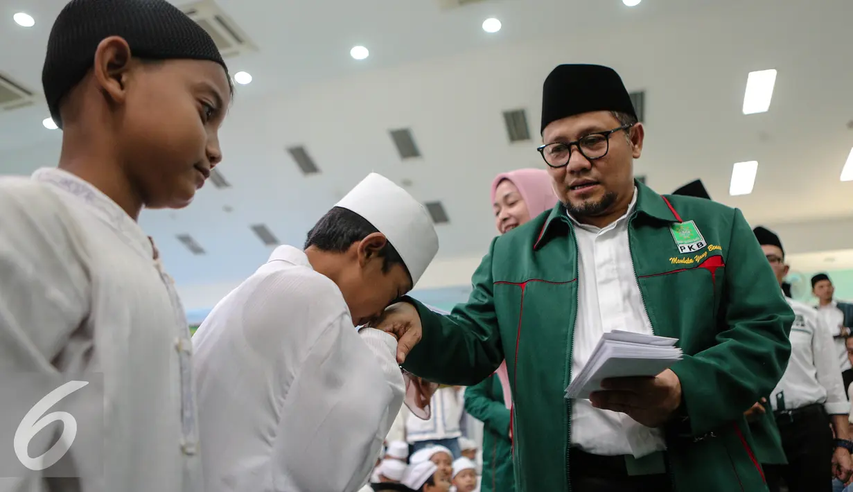 Ketua Umum PKB, Muhaimin Iskandar memberikan santunan kepada anak yatim saat peringatan Hari Lahir (Harlah) ke-17 PKB di Kantor DPP PKB, Jakarta, Kamis (23/7/2015). Harlah tersebut dihadiri oleh ratusan anak yatim. (Liputan6.com/Faizal Fanani)