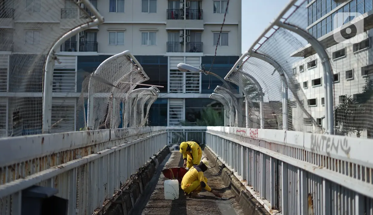 Petugas Bina Marga memerbaiki lantai Jembatan Penyeberangan Orang (JPO) yang berlubang di kawasan Tebet, Jakarta, Kamis (27/8/2020). Perbaikan dilakukan guna meningkatkan kenyamanan bagi pejalan kaki yang melintas. (Liputan6.com/Immanuel Antonius)