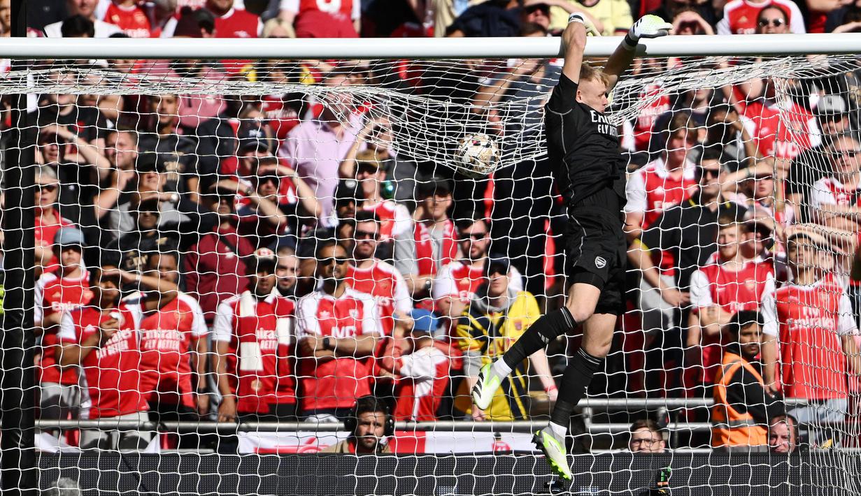 Kiper Arsenal, Aaron Ramsdale, berusaha menghalau bola saat melawan Manchester City pada laga Community Shield di Stadion Wembley, London, Minggu (6/8/2023). Arsenal mengalahkan Manchester City 4-1 lewat adu penalti setelah bermain imbang 1-1 selama 90 menit. (AFP/Justin Tallis)