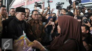 Ketua DPR Ade Komarudin (kiri) berbincang dengan calon penumpang pesawat di Bandara Soekarno Hatta, Banten, Rabu (29/6). Kunjungan tersebut melihat kesiapan pemerintah dalam melayani transportasi pemudik. (Liputan6.com/Johan Tallo)