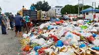 Petugas kebersihan mengangkut tumpukan sampah di Pekanbaru dengan fasilitas operasional terbatas. (Liputan6.com/M Syukur)