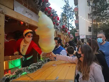 Orang-orang berbelanja di kampung Natal di daerah Ashrafieh, Beirut, Lebanon, 6 Desember 2020. Sebuah kampung Natal dibuka pada Minggu (6/12) bagi para pedagang yang tokonya hancur akibat ledakan pelabuhan pada 4 Agustus lalu. (Xinhua/Bilal Jawich)