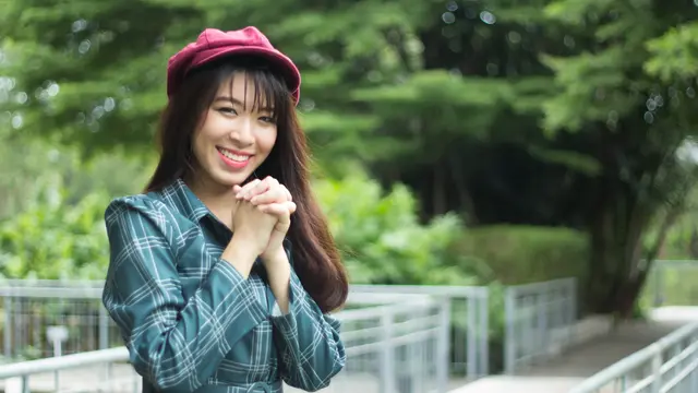 perempuan berharap dan memakai topi