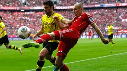 Arjen Robben (Bayern Munich - kanan) mencoba melewati pemain belakang Borussia Dortmund, Sokratis, saat berlaga di ajang Bundesliga di Munich (12/4/2014). (REUTERS/Michaela Rehle)