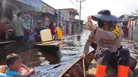 Kapolres Rokan Hilir AKBP Andrian Pramudianto menyapa warga saat memantau banjir. (Liputan6.com/M Syukur)