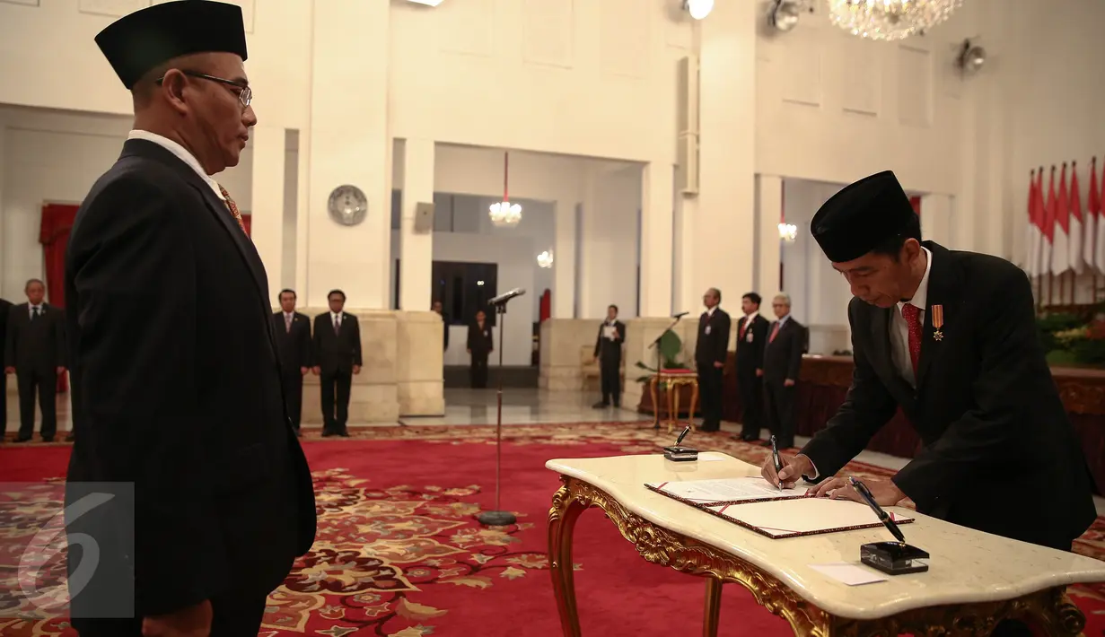 Presiden Jokowi menandatangi dokumen pelantikan Hasyim Asy’ari sebagai anggota Komisi Pemilihan Umum (KPU) di Istana Negara, Jakarta, Senin (29/8). Hasyim menggantikan posisi Husni Kamil Manik yang meninggal pada Juli lalu. (Liputan6.com/Faizal Fanani)