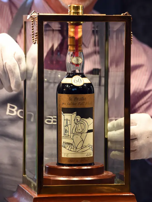 Porter Bonhams menunjukkan botol wiski Macallan Valerio Adamai 1926 pada lelang di Edinburgh, Rabu (3/10). Salah satu wiski paling dicari di dunia ini terjual setelah kolektor pribadi dari Asia memasukkan penawaran melalui telepon. (AFP/Andy Buchanan)