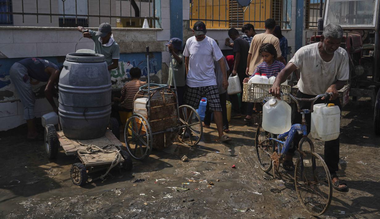 Warga Palestina mengumpulkan air minum di pabrik desalinasi di Deir al-Balah, Jalur Gaza Tengah, Rabu 13 Agustus 2025. (AP Photo/Abdel Kareem Hana)