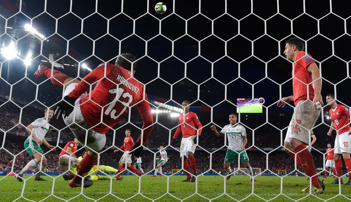 Bek Swiss, Ricardo Rodriguez menendang bola pada leg kedua fase playoff Piala Dunia 2018 zona Eropa melawan Irlandia Utara di St Jakob Park Stadium, Minggu (12/11). Swiss unggul agregat 1-0 atas Irlandia Utara. (Peter Klaunzer/Keystone via AP)