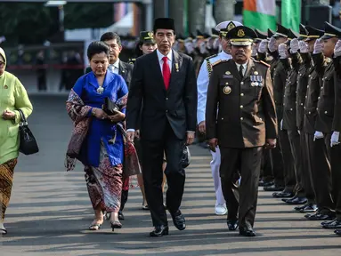 Presiden Joko Widodo (ketiga kiri) bersama ibu negara, Iriana didampingi Jaksa Agung M. Prasetyo (keempat kiri) menuju lapangan upacara Peringatan Hari Bhakti Adhyaksa ke-55 di Kejaksaan Agung, Jakarta, Rabu (22/7/2015). (Liputan6.com/Faizal Fanani) 