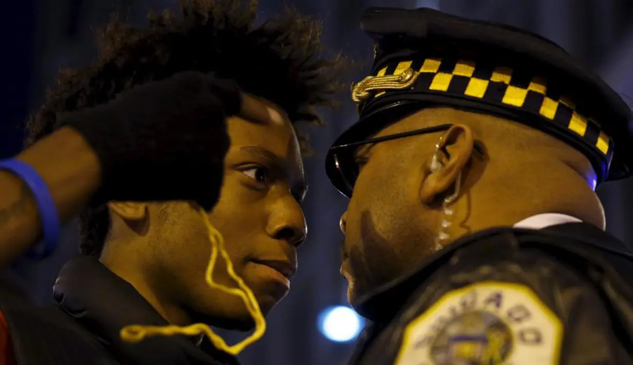 Pengunjuk rasa berhadapan dengan petugas kepolisian di Chicago, Illinois (25 /11/2015). Mereka memprotes karena seorang warga kulit hitam ditembak mati oleh Polisi berkulit putih. (REUTERS / Andrew Nelles)