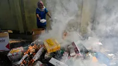 Petugas Bea dan Cukai membakar barang hasil penindakan berupa rokok impor ilegal saat pemusnahan di Banda Aceh, Aceh, Selasa (22/7/2025). (CHAIDEER MAHYUDDIN/AFP)