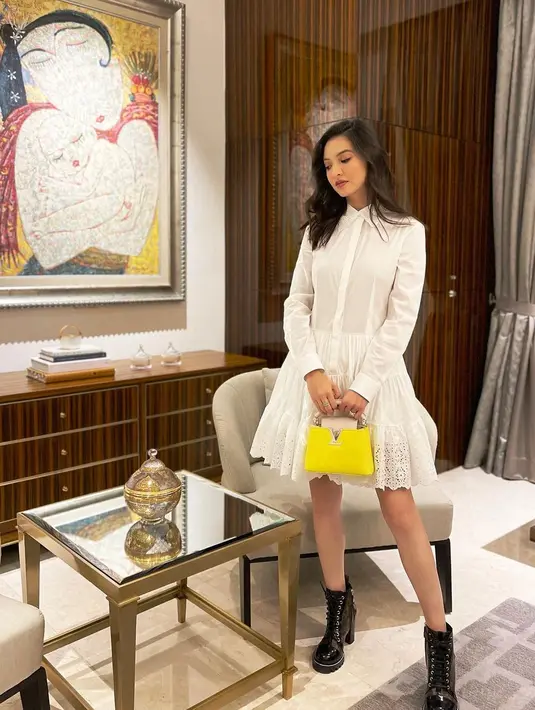 Nuansa sedikit berbeda ditampilkan Raline Shah dengan ankle boots hitam. Ia justru memadukan lace shirt dress lengan panjang dengan detail ruffle di bagian bawah. Handbag berwarna kuning menjadi cukup mencolok di tampilan hitam putihnya. (instagram/ralineshah)
