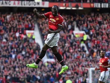 Penyerang Manchester United, Romelu Lukaku berselebrasi setelah mencetak gol ke gawang Everton pada laga pekan kelima Liga Inggris 2017/2018 di Stadion Old Trafford, Minggu (17/9). Setan Merah meraih kemenangan dengan skor nyaman 4-0. (Oli SCARFF / AFP)