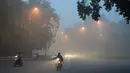 Warga India memacu kendaraannya melintasi jalan di New Delhi, India yang tertutup kabut asap akibat polusi udara, Rabu (8/11). Asosiasi Medis India mengumumkan kondisi darurat kesehatan setelah kabut asap tebal menutupi kota tersebut. (SAJJAD HUSSAIN/AFP)
