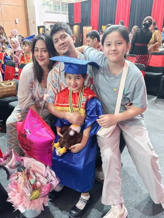 Putri Audy Item dan Iko Uwais, Aneska juga baru lulus TK. Ia tampil mengenakan jubah biru senada dengan warna toganya. [@audyitem]