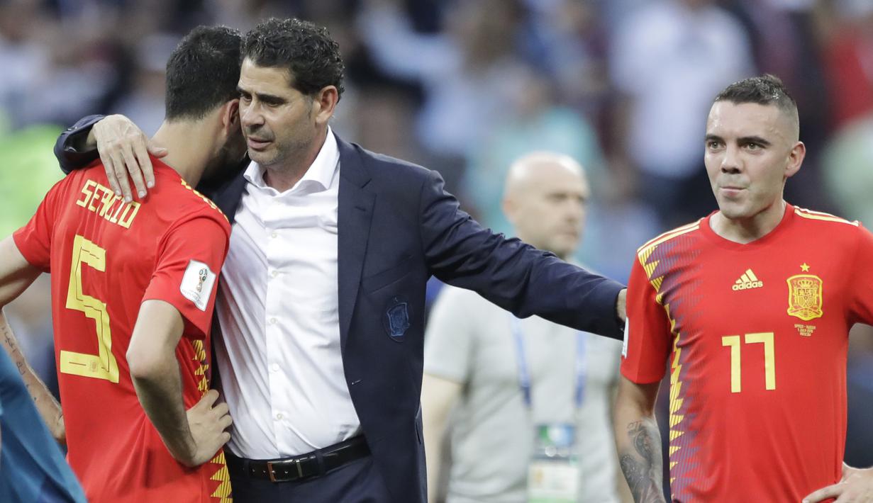 Pelatih Spanyol, Fernando Hierro memberikan semangat kepada Sergio Busquets (kiri) dan Iago Aspas usai kalah dari Rusia pada laga 16 besar Piala Dunia 2018 di Luzhniki Stadium, Moskow, Rusia, (1/7/2018). Spanyol kalah 3-4. (AP/Matthias Schrader)