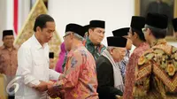 Presiden Joko Widodo berjabat tangan dengan Ketua Umum PP Muhammadiyah Haedar Nashir sebelum melakukan pertemuan di Istana Merdeka, Jakarta, Selasa (1/11). (Liputan6.com/Faizal Fanani)