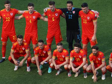 Formasi "berantakan" Timnas Wales mengundang perhatian kala mereka berjumpa dengan Timnas Swiss di laga perdana Grup A Euro 2020. Berbeda dengan pose tim pada umumnya, mereka dengan sengaja memilih bergaya asimetris dan terkesan berantakan. (Foto: AFP/Pool/Naomi Baker)