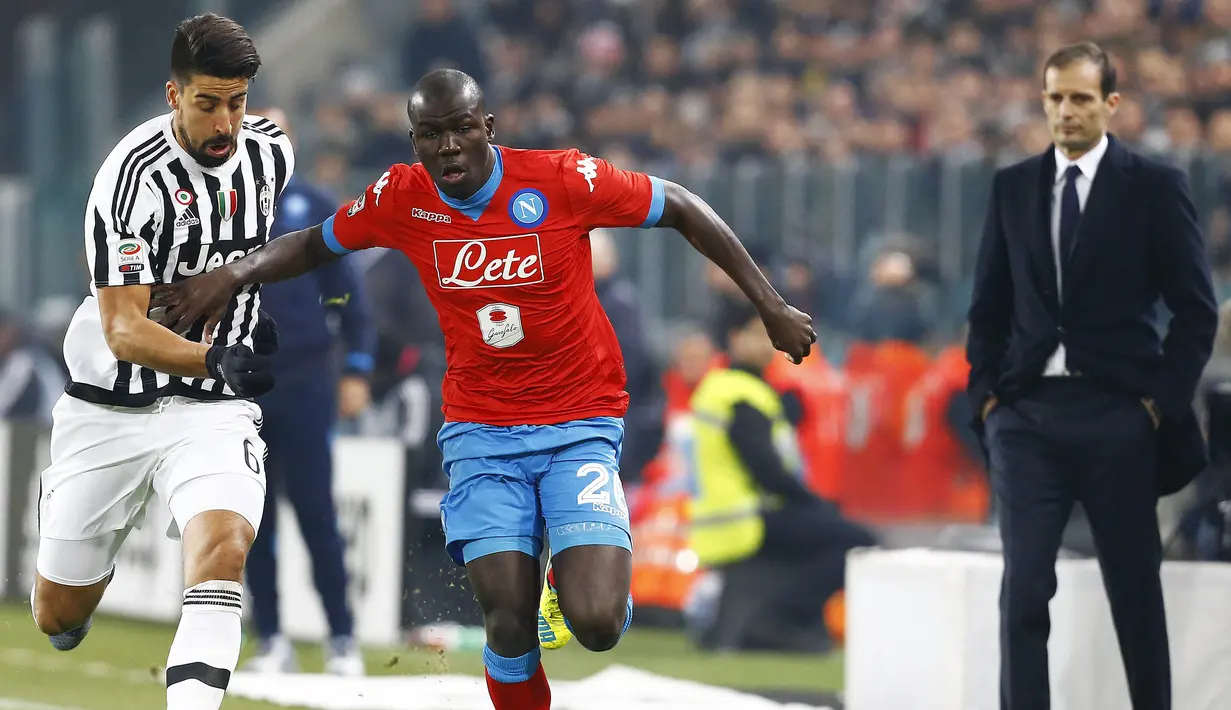 Gelandang Juventus, Sami Khedira, berebut bola dengan pemain Napoli, Kalidou Koulibalu. Berkat kemenangan ini Juventus berhasil menggeser Napoli dari pimpinan klasemen. (Reuters/Stefano Rellandini)