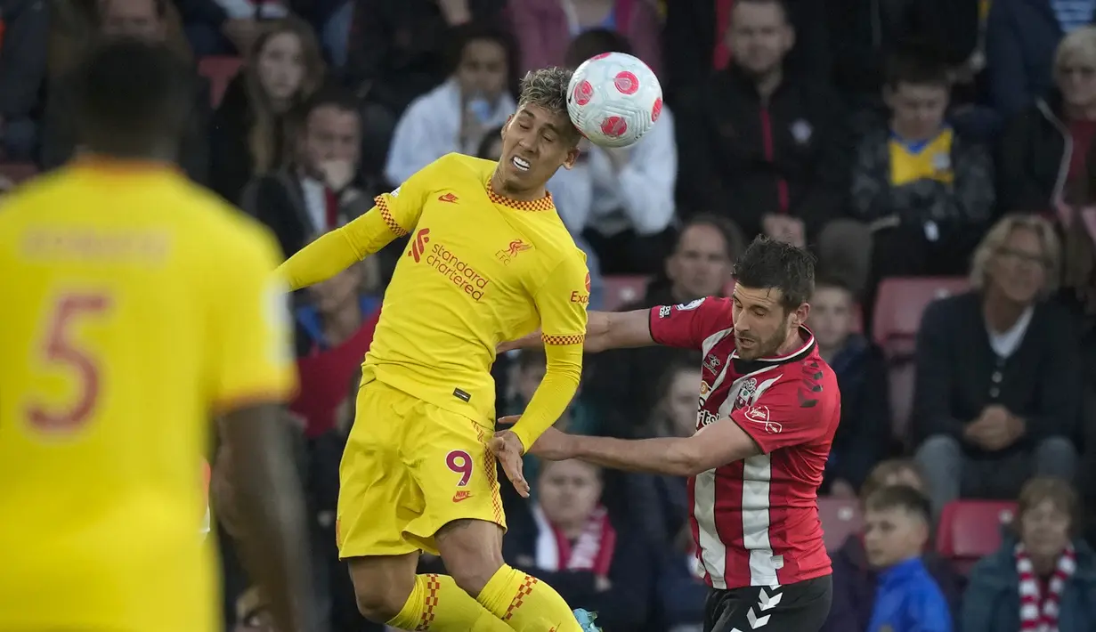 Penyerang Liverpool, Roberto Firmino berebut bola dengan pemain Southampton, Jack Stephens pada pertandingan lanjutan Liga Inggris di Stadion St. Mary di Southampton, Inggris, Rabu (18/5/2022). Kemenangan ini membuat Liverpool terus menempel Manchester City di puncak klasemen. (AP Photo/Frank Augstein)