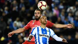 Bek Real Madrid, Dani Carvajal berebut bola dengan pemain Leganes, Martin Braithwaite dalam lanjutan La Liga 2018-2019 di Estadio Municipal Butarque, Senin (15/4). Real Madrid hanya mampu meraih hasil imbang 1-1 saat bertandang ke markas Leganes. (PIERRE-PHILIPPE MARCOU / AFP)