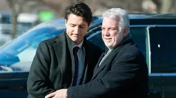 PM Kanada, Justin Trudeau menyapa Wali Kota Quebec, Philippe Couillard setibanya di Montreal Olympic, Kamis (2/2). PM Kanada menghadiri upacara pemakaman tiga dari enam korban penembakan di Masjid Quebec. (Graham Hughes/The Canadian Press via AP)