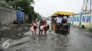 Sejumlah pelajar berjalan menembus banjir di Kawasan Muara Angke, Jakarta, Rabu (11/1). Akibat banjir ini juga aktivitas warga menjadi terganggu. (Liputan6.com/Gempur M. Surya)