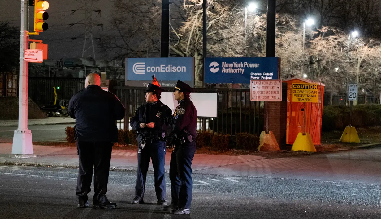 Departemen Kepolisian New York (NYPD) berjaga di depan perusahaan Con Edison, distrik Queen setelah ledakan trafo listrik, Kamis (27/12). Ledakan menyebabkan cahaya biru menerangi langit New York dan membuat kegemparan di media sosial. (AP/Craig Ruttle)