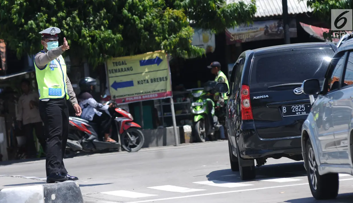 Petugas mengatur arus lalu lintas di Simpang Tiga Keluar Tol Brebes, Jawa Tengah, Sabtu (23/12). Memasuki libur panjang Natal 2017, arus lalu lintas di Simpang Tiga Keluar Tol Brebes terlihat ramai lancar. (Liputan6.com/Helmi Fithriansyah)