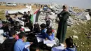 Anak-anak belajar di antara puing sekolah mereka yang hancur di Tepi Barat, Palestina, Minggu (4/2). Setidaknya 45 sekolah di Palestina tengah menghadapi ancaman kehancuran yang dilakukan oleh otoritas Israel. (AP Photo/Mahmoud Illean)