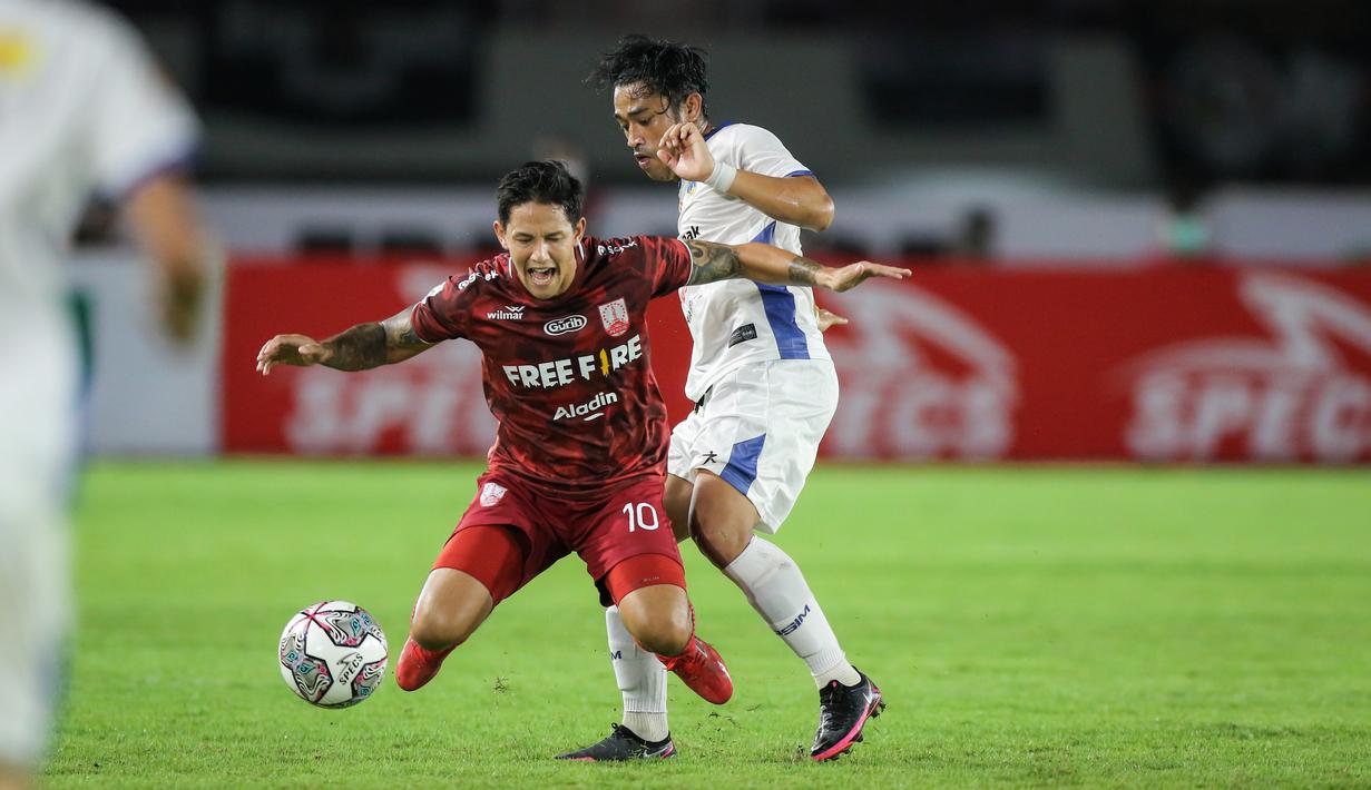 Pemain Persis Solo, Irfan Haary Bachdim (kiri) berebut bola dengan pemain PSIM Yogyakarta, Beny Wahyudi saat matchday ke-8 Grup C Liga 2 2021 antara Persis Solo melawan PSIM Yogyakarta di Stadion Manahan, Solo, Senin (15/11/2021). (Bola.com/Bagaskara Lazuardi)