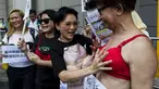 Pengunjuk rasa memakai bra di luar markas polisi di kawasan Wan Chai, Hong Kong, Minggu (2/8). Demo tersebut merupakan aksi simpati terhadap seorang perempuan yang di penjara karena dituduh menyerang polisi menggunakan payudaranya. (REUTERS/Tyrone Siu)