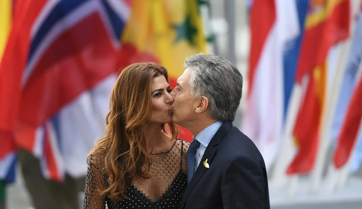 Presiden Argentinia Mauricio Macri mencium istrinya Juliana Awada saat mereka tiba menghadiri KTT G20 di aula Elbphilharmonie di Hamburg, Jerman, (7/7). Sejumlah pemimpin negara berkumpul dalam KTT G20 pada 7-8 Juli 2017. (AFP Photo/Patrick Stollarz)