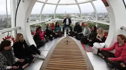 Will Williams (tengah) memimpin meditasi di salah satu dari tiga kapsul London Eye di London, Inggris (15/5). Kegiatan meditasi ini bertujuan untuk mempromosikan Hari Meditasi Dunia. (AP Photo / Alastair Grant)
