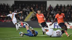 Gelandang AS Roma Nicolo Zaniolo berebut bola dengan kiper Istanbul Basaksehir, Mert Gunok pada laga kelima Grup J Liga Europa 2019-2020 di stadion Fatih Terim, Kamis (28/11/2019). AS Roma menang meyakinkan dengan skor 3-0.  (Ozan KOSE / AFP)