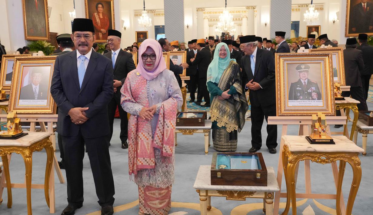 Putra dan putri mendiang Presiden ke-2 RI, Suharto, Siti Hardiyanti Rukmana (kedua dari kiri) dan Bambang Trihatmojo berpose di samping potret ayah mereka dalam upacara penganugerahan gelar pahlawan nasional kepada sepuluh tokoh di Istana Negara, Jakarta, Senin 10 November 2025. Presiden Prabowo Subianto resmi memberikan gelar pahlawan nasional kepada Presiden ke-2 Republik Indonesia, Soeharto. (AP Photo/Achmad Ibrahim)