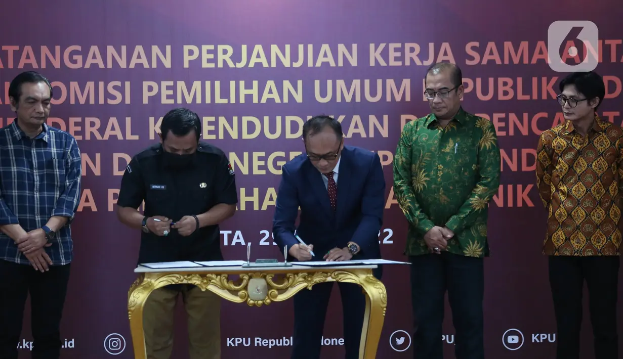 Sekretaris Jenderal KPU RI Bernad Dermawan Sutrisno (kedua kiri), Dirjen Dukcapil Zudan Arif Fakrulloh (tengah), dan Ketua KPU RI Hasyim Asy'ari (kedua kanan) saat penandatanganan perjanjian kerja sama antara Direktur Jenderal Dukcapil Kemendagri dengan Sekretaris Jenderal KPU RI di Gedung KPU, Jakarta, Rabu (29/6/2022). Kerja sama ini mengenai pemanfaatan nomor induk kependudukan, data kependudukan, dan kartu tanda penduduk elektronik dalam pemutakhiran data pemilih. (Liputan6.com/Angga Yuniar)