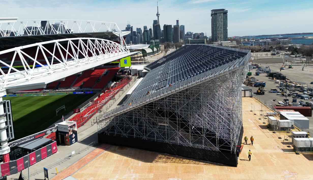 Stadion olahraga multiguna yang terletak di Exhibition Place, Toronto, Kanada, ini melakukan penambahan kapasitas kursi penonton. Tampak dalam foto, tempat duduk tribun sementara dipasang untuk menambah kapasitas penonton di dekat tribun reguler di BMO Field, Toronto, Kanada, pada Selasa 24 Maret 2026. (Cole BURSTON/AFP)