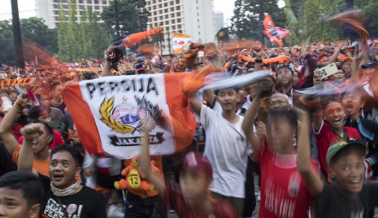 Suporter Persija Jakarta, The Jakmania, merayakan gelar juara Liga 1 saat nonton bareng di Plaza Timur Senayan, Jakarta, Minggu (9/12). Persija juara Liga 1 setelah menang 2-1 atas Mitra Kukar. (Bola.com/Peksi Cahyo)