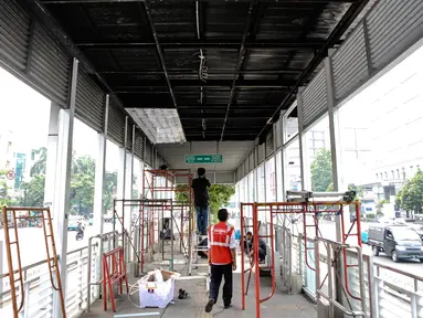 Pekerja menyelesaikan perbaikan halte transjakarta yang terbakar di Salemba, Jakarta, Selasa (7/7/2015). Halte tersebut rusak parah sebagai imbas dari terbakarnya bus Transjakarta koridor 5 pada hari Jumat (3/7) lalu. (Liputan6.com/Faizal Fanani)