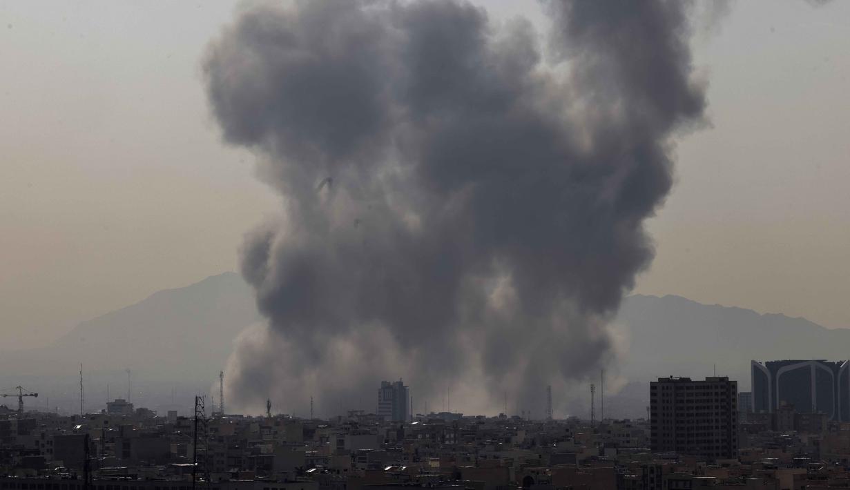 Dua kepulan asap tebal terlihat di atas pusat dan timur ibu kota Iran, Teheran. Tampak dalam foto, kepulan asap membubung setelah ledakan yang dilaporkan terjadi di Teheran, Iran, pada 28 Februari 2026. (ATTA KENARE/AFP)