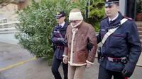 Dalam gambar yang diambil dari video pada Senin, 16 Januari 2023 menunjukkan bos mafia nomor satu di Italia Matteo Messina Denaro (tengah) meninggalkan barak Carabinieri Italia segera setelah penangkapannya di sebuah klinik swasta di Palermo, Sisilia. Matteo Messina Denaro (60) salah satu penjahat paling dicari di dunia ditangkap setelah buron selama 30 tahun. (Carabinieri via AP)