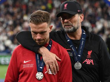 Kapten tim Liverpool, Jordan Henderson (kiri) telah resmi meninggalkan Klub untuk bergabung dengan  Al Ettifaq. Henderson tercatat lebih dari satu dekade memperkuat Liverpool. Ia juga dipercaya oleh Jurgen Klopp untuk memimpin Liverpool disetiap pertandingan selama karirnya. (AFP/Franck Fife)