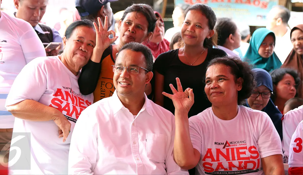 Cagub DKI Jakarta, Anies Baswedan (tengah) berfoto bersama warga jelang sosialisasi di Rusun Karet Tengsin, Jakarta, Rabu (28/12). Anies juga melantik koordinator tim pemenangan tingkat Rt dan Rw di Karet Tengsin. (Liputan6.com/Helmi Fithriansyah)
