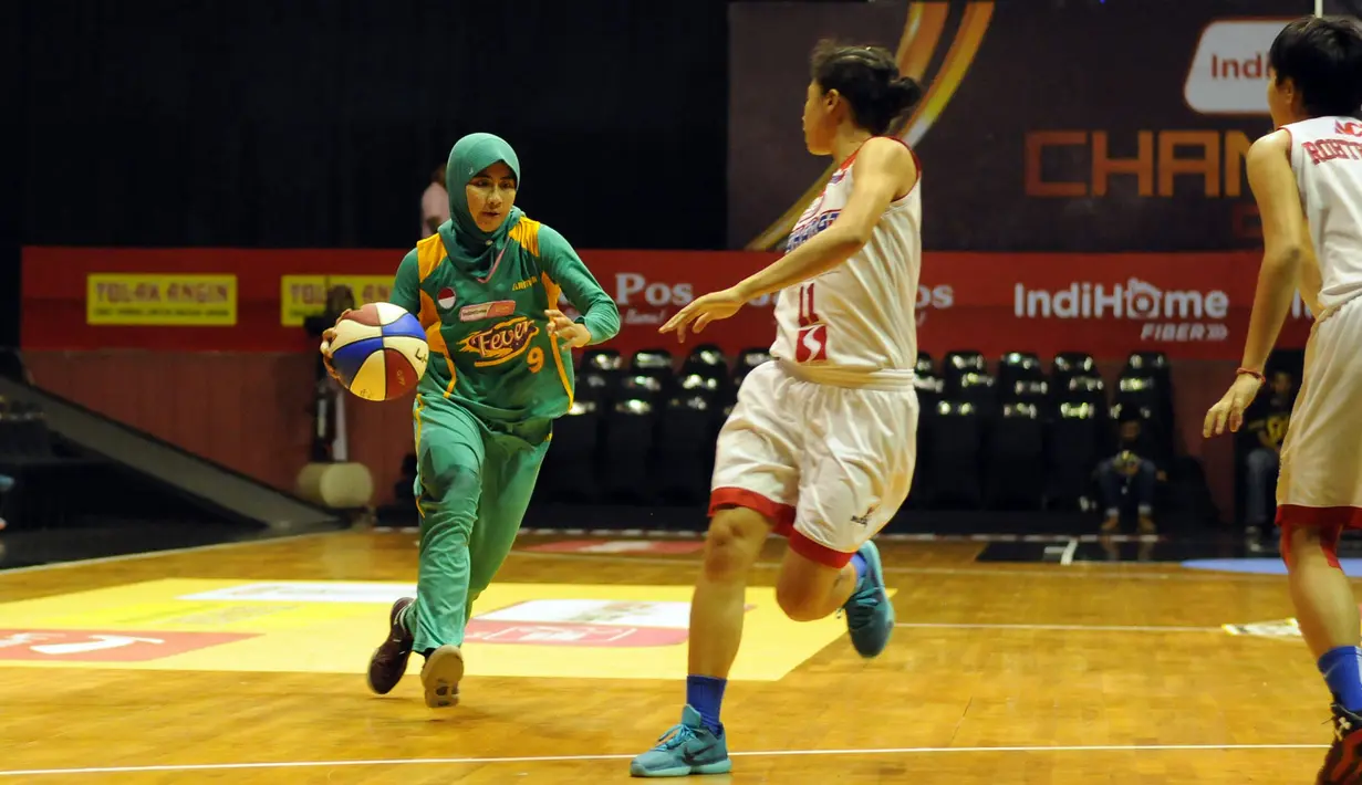 Pebasket putri Surabaya Fever, Raisa Hamidah (kiri) mencoba melewati hadangan dua pemain Sahabat Wisma Sehati Semarang di final WNBL Championship 2015 yang berlangsung di Hall A Senayan, Jakarta, Jumat (8/5/2015). (Liputan6.com/Helmi Fithriansyah)