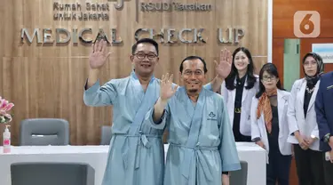 Pasangan bakal calon gubernur dan wakil gubernur DKI Jakarta, Ridwan Kamil (kiri) dan Suswono (kedua kiri) sesaat sebelum menjalani pemeriksaan kesehatan di RSUD Tarakan, Jakarta, Sabtu (31/8/2024). (Liputan6.com/Angga Yuniar)