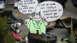 Sebuah pesan diletakkan diantara sepatu yang dipajang di place de la Republique, Prancis, sebagai tanda solidaritas karena pawai lingkungan di Paris dibatalkan jelang KTT Perubahan Iklim, Minggu (29/11).(AFP PHOTO/Joel SAGET)